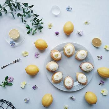 レモンケーキをまるいお皿にきれいに並べて。そのまわりを囲むようにフレッシュレモンとビオラの花を散りばめて。まるでケーキをデコレーションするかのように美しく飾られたテーブルが素敵です。
