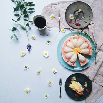 お花形のケーキにそっくりな、白くて小さなスノーポールの花を散りばめて。余白に可愛らしいアクセントを加えるテクニックが光ります。