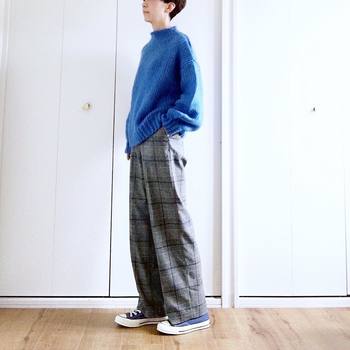 鮮やかなブルーのニットが印象的。シンプルなデザインのグレンチェックは、トップスを主役にしたコーデにもぴったり。