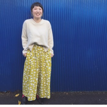北欧風の花柄スカートは、シンプルな白色ニットと合わせて。前だけちょこんと入れる“前だけイン”の方法は、バランスを上手くとりづらい服装や、ウエストラインが見えてしまうのが嫌だという方にもおすすめの着こなしです。