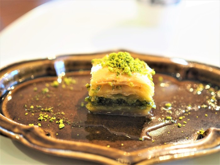 こちらはトルコの伝統的なお菓子「バクラヴァ」。パイ生地の間に小さく潰したピスタチオを挟んでいます。全体に甘いシロップがかかっていて、サクサク感としっとり感の両方が味わえます。地域によって、ナッツの種類やシロップの量など、多少の違いはありますが、シロップの甘さが特徴的なトルコの人気菓子です。