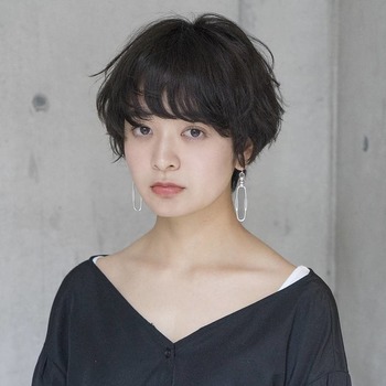 アンニュイな雰囲気を醸すほつれパーマ。髪色はクールにきまる暗めのトーンで。