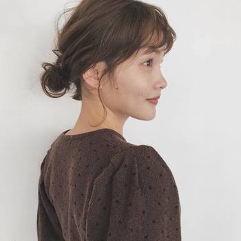 ビビッドなイエローのドレスには、ふんわりとしたおだんごヘアで、優しいニュアンスを。ゆるりと取ったおくれ毛が、こなれ感のある雰囲気に。