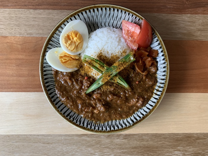 『カレーの恩返しカレー』ではご家庭によって様々なアレンジを楽しむ事が出来ます。今回はInstagramでアレンジを楽しむ方にお声がけをさせていただきました!また、キナリノ編集部でも実際に作ってみましたので、是非アレンジの参考にしてみてくださいね。
ましましスパイスをたっぷりとかけたこちらのカレーには、夏野菜のトマトとオクラのを盛りつけてみました。味に深みをプラスしてくれるマシマシスパイスによって、ピリッとスパイシーさを感じることができ、またしっかりとしたカレーのコクを味わえます。
【編集部撮影画像】