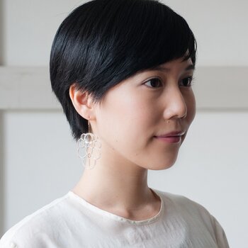 松ぼっくりはお祝いのモチーフに用いられることから、「祝」の漢字を構成する「ネ・ロ・ル(NEROL)」と名付けられたそうです。そのネーミングの通り、華やかな雰囲気が魅力的なNEROLのイヤリングは、結婚式などハレの日のジュエリーにもぴったり。エレガントなドレスにもマッチして、特別な日の装いを優雅に演出してくれます。(こちらはピアスからイヤリングの金具に交換できます)