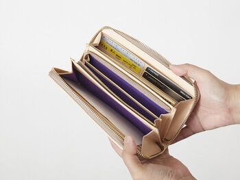 中は仕切りが多く、お札もカードもたっぷり収納可能。鍵やお守りも入るサイズ感です。ファスナータイプなのでレシートや小銭が溜まってもきっちり口を閉じることができ、急いでいるときに整理整頓を強いられない手軽さが実用的。