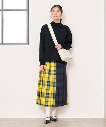 個性的な3色のパッチプリーツスカートは、チェック柄を引き立たせるため、他のアイテムはあえてモノトーンカラーでまとめるのが正解です。重たい印象にならないよう、ショルダーバッグやソックスを白系にして軽やかに。