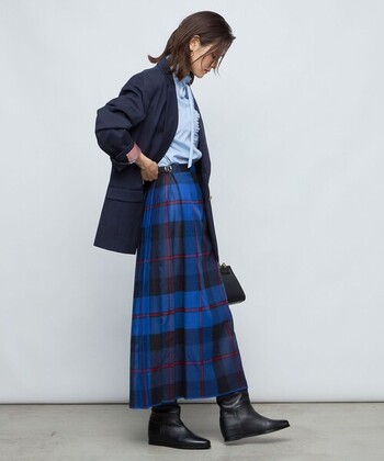 ブルー系のロングキルトスカートに、紺ブレを羽織ったトラッドスタイルです。袖のロールアップや黒のロングロングブーツでマニッシュに仕上げています。