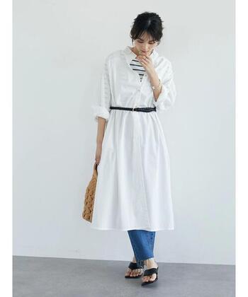 白シャツワンピの下にボーダーTシャツやデニムをレイヤードしたスタイリング。ほんのり透けるボーダーがおしゃれです。細い黒ベルトでウエストマークすることで、スタイルアップが叶います。