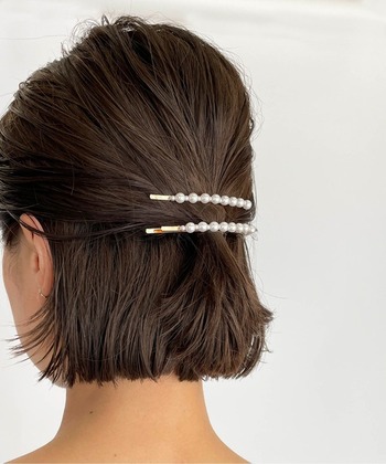 ハーフアップの結び目部分に、パールピンを2本重ね付けした簡単アレンジ。毛先は内巻にワンカールして上品な雰囲気です。