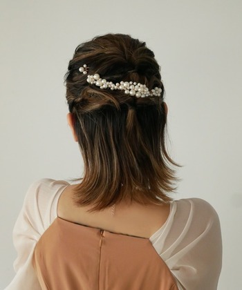 ダブルくるりんぱのハーフアップアレンジに、パールのヘアコームを複数挿しこんだアレンジ。大小のパールが並んだデザインで、斜めに付けると動きが出て華やかです。