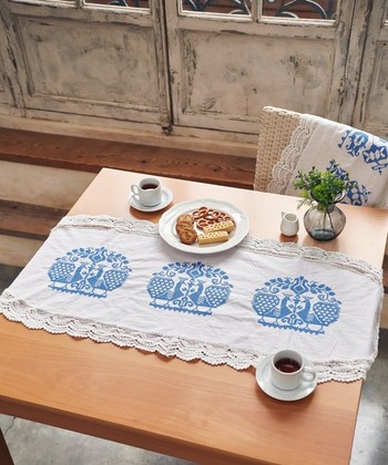 ヨーロッパの伝統柄をクロスステッチであしらったテーブルクロス。商品名にある“サムシングブルー”という風習があり、青色の取り入れると幸せになれるといわれています。モチーフは2種類で、クロシェレースのトリミングがアクセント。クラシカルな雰囲気のテーブルコーディネートにお似合いです。