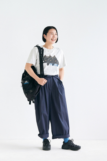 「ボーイッシュだったり、きれいめだったり、合わせるアイテム次第で印象が変わるネイビー。今回は旅行をイメージしたスタイリングに。１日目はそのまま一枚で着用して、翌日はボトムスとしてTシャツ合わせに、みたいな着こなしができるのもオールイワンのいいところ。半袖なので長袖のオールイワンのように袖を腰で結べないのですが、中のゴムをぎゅっと絞ってボタンを留めておけば落ちてくる心配はないので、安心して着用できます！」