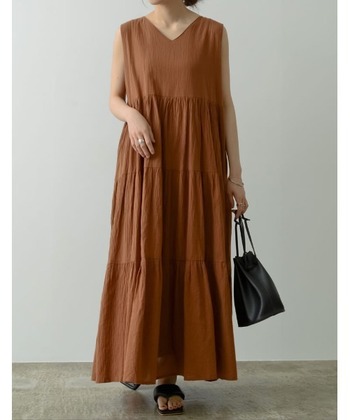 ドレープが美しいティアードワンピースは、風通しがよくリゾート感たっぷりのアイテム。黒レザーバッグ＆サンダルを合わせると、ラフすぎず大人な装いが叶います。