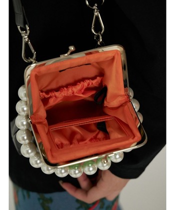 がま口を開ければそこにはミラーが！　人知れずこっそりメイクチェックができるという優れもです。

さらに外側のポケットのファスナーを開けると、そこにはカード用ポケットも。ポシェットとしてはもちろん、お財布として使ってもいいかもしれません。