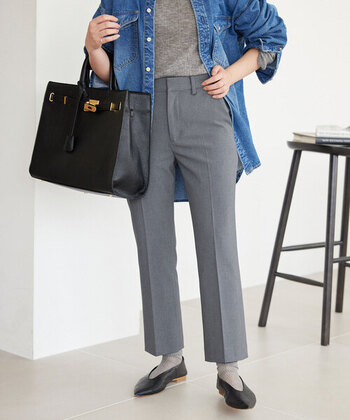 きれいめなグレーのワンツーコーデに、あえて大きめのデニムシャツを羽織ったスタイリング。黒の大きめバッグとポインテッドトゥのパンプスでエッジを効かせてクールな印象です。