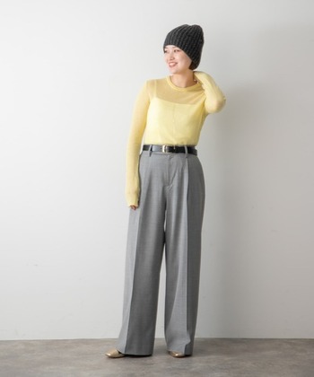 グレーのワイドスラックスに、ブルーのストライプシャツにグリーンのショート丈ニットを重ね着したスタイリング。色の組み合わせや裾出しのバランスが絶妙です。黒のメガネとレザーシューズで知的な印象をプラスして。