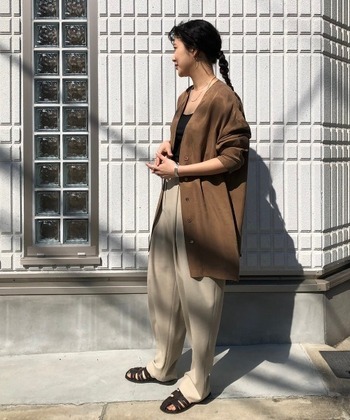 ライトブラウンのシャツジャケット×ベージュパンツのきれいめコーデ。ヒップまで隠れるミドル丈のゆったりシルエットがこなれた印象に。黒のタンクトップやサンダルを引き締め役にした、晩夏から初秋におすすめのスタイリングです。