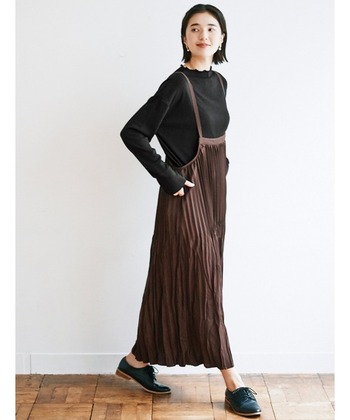 表情豊かなランダムプリーツのキャミワンピース。インナーに合わせた黒のカットソーのフリルネックがフェミニンです。ストラップを長めに調節することで、大人っぽい着こなしに。