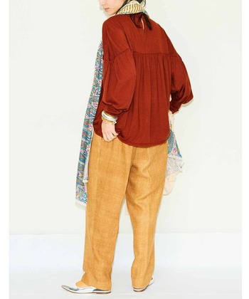 レッドブラウンのシャツにマスタードイエローのテーパードパンツを合わせたスタイリング。茶色はシックなイメージがありますが、トーンアップした赤みブラウンは明るい印象に見せてくれます。柄スカーフとシルバーパンプスで、ほんのり個性的に。