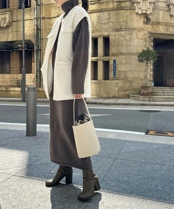 グレーのハイネックニットワンピース一枚だとシンプルすぎる……。そんなときは、ボアベストを羽織ってみて。もこもこの質感が見た目にも暖かくニュアンスをプラス。こちらのニットワンピースは、袖口に指穴が開いているので女性らしい萌え袖スタイルを楽しめます。