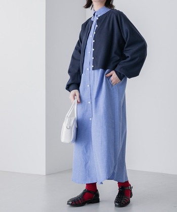 ダンガリーシャツワンピースに、ネイビーカーディガンを羽織った大人カジュアルコーデ。全体的にゆったりとしたシルエットながらも、ショート丈のおかげで目線が上に行きすっきりと見えます。足元は、グルカサンダル×赤ソックスで差し色のアクセントを。