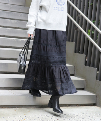 段々の切り替え部分にふんだんにレースを使用した繊細なスカートに、カジュアルなロゴスウェットをオン。スカートの色に合わせブーツやバッグも黒でまとめて、抜け感はありつつもシックに仕上がっています。