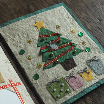 スパンコールやビーズ、リボンなどがオーナメントやプレゼントの飾りに使われた立体的なクリスマスカード。華やかさと遊び心がプラスされた、かわいらしいカードです。
