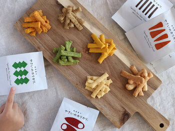 「お母さんが子どもに食べさせたいお菓子」がコンセプトのやさいのカリカリ。長崎県産の新鮮な野菜を材料の30〜40％も使い、卵・乳・小麦粉・白砂糖不使用の油で揚げていないノンフライスナックです。