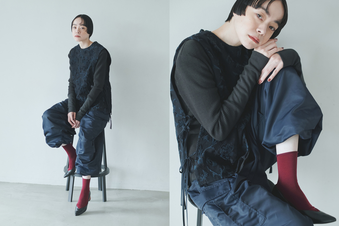 ネイビー×ブラックの落ち着いたワントーンコーデ。パンツの光沢で華やかさを添えて。そこにダークレッドの靴下を足すだけで、グッとこなれた印象に。ヒールのあるきれいめパンプスを選べば、足元まで抜かりないシックな装いの完成です。