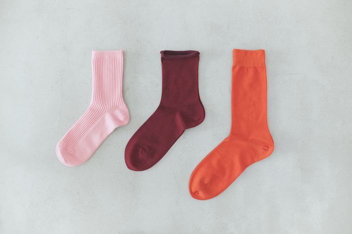 （左）PURE WOOL 2×2リブソックス（ペールピンク）￥1,320／靴下屋
（中央）ハイゲージ梳毛ロールショートソックス（ダークレッド）￥1,320／Tabio
（右）ハイゲージ梳毛ベタソックス（キャロット）￥1,430／Tabio
