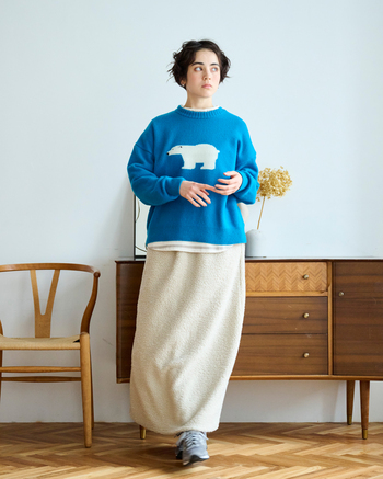 可愛らしさと大人のユーモアが程よく同居した、リラックス感のある冬の着こなし。鮮やかなブルーに白クマのモチーフが映えるニットは、着るたびに心までほっと和みます。タスマニアラムウールを使用し、なめらかな肌ざわりで着心地も◎。ゆるやかなシルエットが、全体を穏やかなムードに導きます。