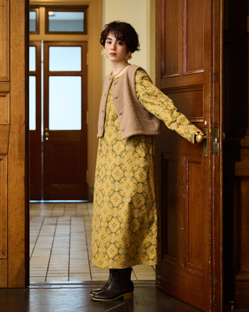 一枚でサマになるマスタード色の花柄ワンピースは、起毛をかけたビエラ素材のふんわりとした風合いが魅力。小花が散りばめられたプリントで、可憐な印象を与えてくれます。モコモコ素材のベストを重ねれば、あたたかみのある冬の装いに。気負わず着られて、特別感を添えてくれるおめかしスタイルの完成です。