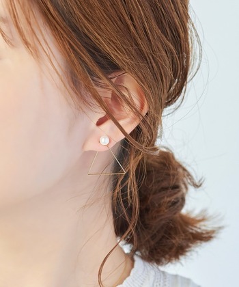 髪を後ろでふんわり束ねて、トライアングルのモチーフと上品パールのイヤリング。