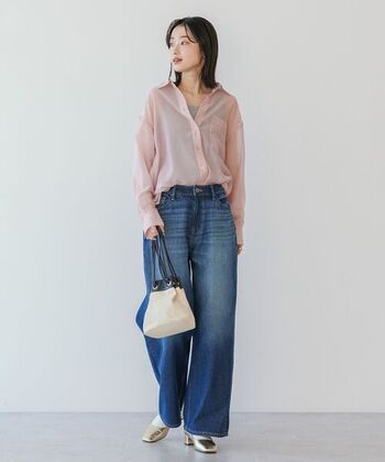 ピンクのシアーシャツからグレーのタンクトップをあえてチラ見せした着こなし。シャツにデニムパンツを合わせた王道スタイルですが、インナーを少しのぞかせることでこなれた印象に。ゴールドパンプスの輝きが華やかさとモード感をプラスしています。