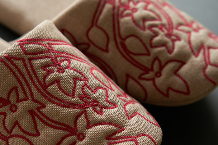 チェーンステッチ風の刺繍がほどよい存在感を添え、控えめながらも上品さが漂うデザイン。さらっとした織生地を使っているので、季節を問わず取り入れやすく、来客用として用意しておくのにもぴったりです。つま先が少し上がったつまずきにくい仕様で、丸洗いもOK。