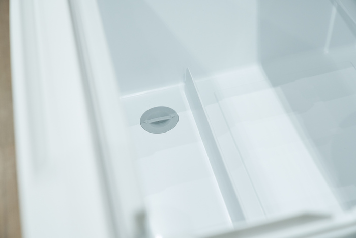 引き出したときに調味料が倒れづらくなるガードと、おそうじ栓。元々おそうじ栓は、ファミリー向けの超大型冷蔵庫で採用されており、今回、小型冷蔵庫への導入はAQUA初。数々の冷蔵庫を手がけるお二人だからこそ実現した機能。