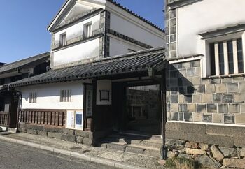 【画像の建物は「倉敷民藝館」。江戸後期に建てられた米蔵を活用したものです。白壁に貼り瓦の外壁、和瓦の建築スタイルは、当地方の典型的な土蔵造りです。】