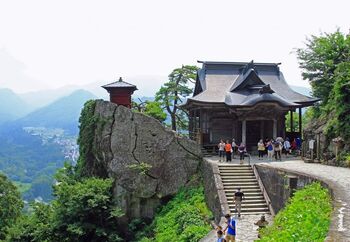 山寺の通称で知られる「立石寺(りっしゃくじ)」。創建は古く860年にさかのぼり、松尾芭蕉の有名な句、『閑さや 岩にしみ入る 蝉の声』が詠まれた寺としても知られています。
さっき通り過ぎた人は、もしや物の怪かも? そんな気分もしてしまう、歴史が刻まれた参道。
途中には、その中に阿弥陀如来のお姿を見ることができる人には、幸福が訪れると伝えられている岩場、「弥陀洞(みだほら)」も。