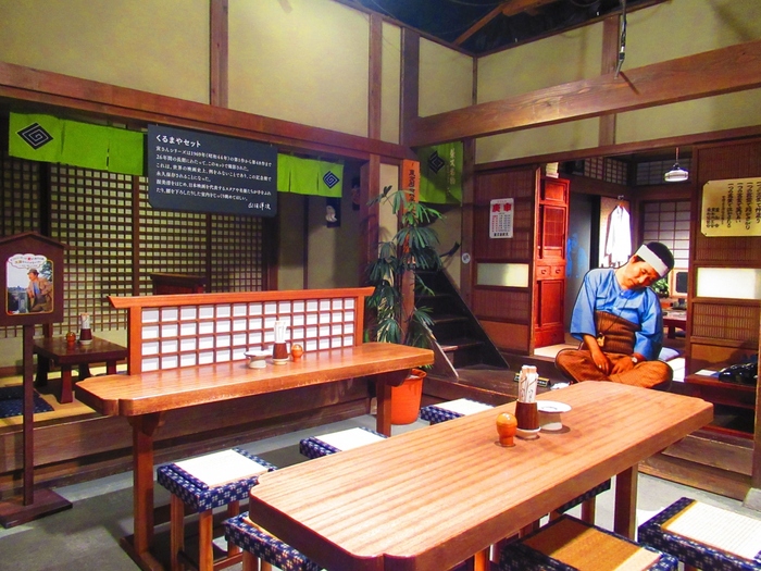 柴又駅から徒歩8分、柴又帝釈天と江戸川の間ほどにある「寅さん記念館」。名誉館長は山田洋次監督です。館内には、実際に映画のセットで使われていた団子屋「くるまや」や、小道具、山田洋次監督が使用したメガホンなど、貴重な品々が展示されています。