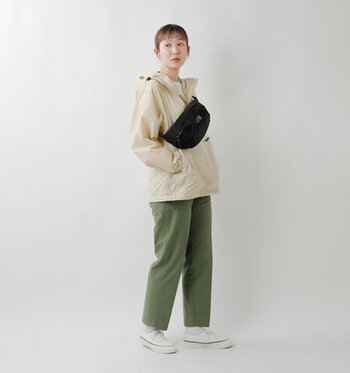 カーキのパンツとベージュのアウター、ホワイトスニーカーで爽やかに仕上げたコーディネート。黒の「THE NORTH FACE」のウエストバッグでクールなワンポイントをプラスしています。