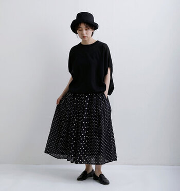 ゆとりのある黒Tシャツにドッド柄のギャザースカートを合わせた上品なワントーンコーデ。ハットやローファーを合わせて、全体的にレディライクなスタイルに仕上げています。