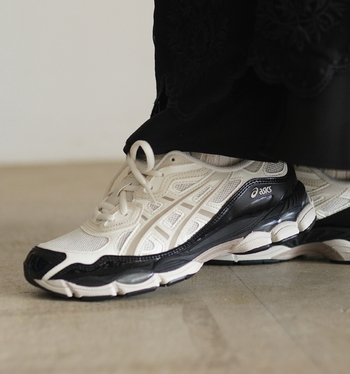「2000年代初頭のランニングシューズを思わせる、立体的なアッパーが特長のASICS「GEL-NYC」。メッシュやスエードを重ねたデザインと、スポーティでありながら洗練された佇まいが魅力です。合わせるなら、ジャスト丈のストレートスラックスを。裾から白いアッパーをのぞかせることで、ボリュームのある一足にも抜け感が生まれ、足元が軽やかに見えます。
かっちりとしたスラックスに、あえてハイテクスニーカーを合わせれば、定番のきれいめスタイルが大人のストリートコーデに。ランニングシューズ由来の設計なので、歩きやすさとデザインの両方を重視したい方におすすめです」(玄長)