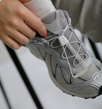 「アウトドアの機能美と都会的な雰囲気を兼ね備えたSALOMONの「XT-WHISPER」。マットと光沢、異なる質感を重ねた立体的なデザインが、足元にモダンでリッチな印象を与えてくれます。合わせるなら、すとんと落ちる長めのワイドパンツやストレートスラックス。裾をスニーカーの上にふわりとのせることで、今っぽいルーズなバランスが生まれます。
細いコードを引くだけでフィット感を調節できるQuicklace™なら、余ったコードをポケットに収納でき、長めの裾にも絡みにくくすっきり。軽量でクッション性に優れ、足への衝撃をやわらかく吸収するため、長時間歩く日にも心強い一足です」(玄長)